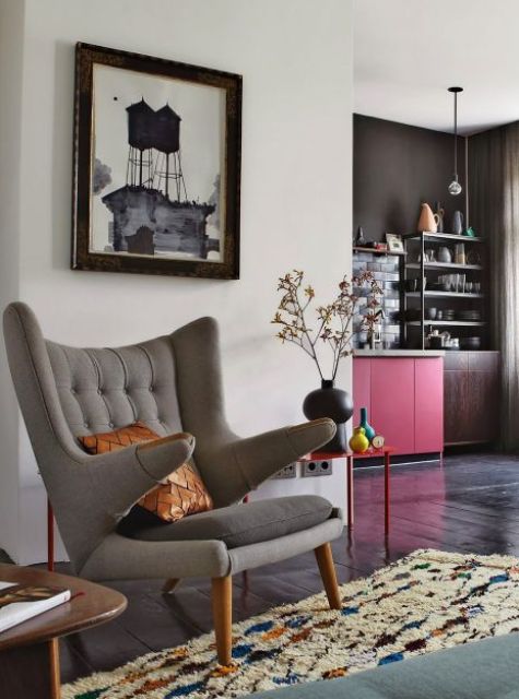 a cool nook with a grey Papa Bear chair and a pillow, a side table with bold decor, a colorful rug and a coffee table