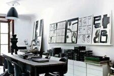 a monochromatic dining room with a table, black Panton chairs, a white storage unit and a black and white gallery wall
