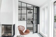 a monochromatic space with floor to ceiling windows, a fireplace, brown leather Swan chairs and a bit of firewood