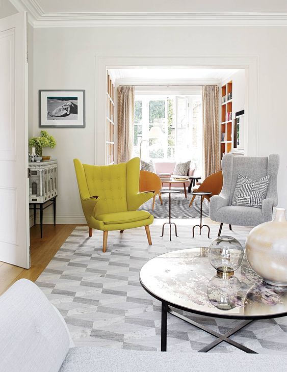 a neutral living room with a grey daybed, a coffee table, a grey chair and a yellow Papa Bear chair is cool