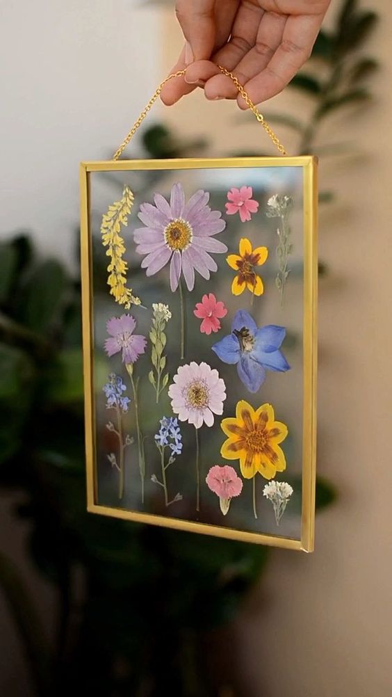 pressed colorful blooms in a gilded frame on chain is a cool and fun idea for summer, they will bring color to the space