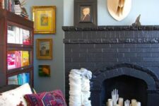 04 a black brick fireplace with pillar candles and hands, with a faux deer head over it is very cool and bold