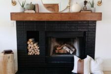 11 a stylish black brick fireplace with a built-in firewood niche, a stained mantel with elegant decor is a gorgeous idea to try