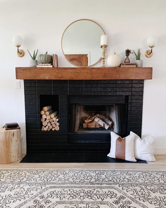 A stylish black brick fireplace with a built in firewood niche, a stained mantel with elegant decor is a gorgeous idea to try
