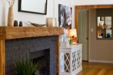 12 a stylish black brick fireplace with a rough wood mantel and frame, with some decor is a bold decor feature