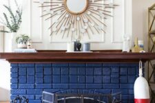 16 a beautiful and chic navy brick fireplace with a metal screen, a stained mantel with decor, a sunburst mirror over the mantel