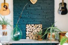 21 a bold boho living room with a navy painted brick fireplace, a wood log screen, potted plants, some decor, a bold rug and an acrylic table
