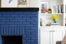 23 a chic modern living room with a grey sofa, a navy brick fireplace, built-in shelves and a cabinet and some bold artwork