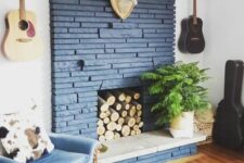 25 a cool midnight blue brick fireplace with logs inside and a potted plant is a lovely decor idea for any modern space