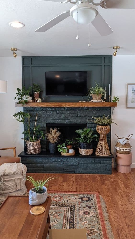 A cool non working graphite grey fireplace with potted plants all over is a perfect fit for a boho space, and plants are a cool alternative to fire