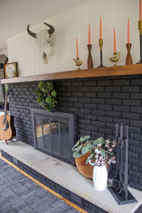 a large graphite grey fireplace with potted plants and arrangements, candles and lovely boho decor is a cool idea for a boho space