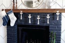 40 a navy brick fireplace with a wooden mantel and some metallic chess inside is a very fresh take on a traditional piece