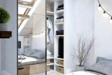 a Scandinavian bedroom with an attic closet, which is separated with a mirror barn door