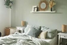 a cute bedroom with a sage green accent wall