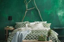 a bold emerald plaster wall plus branches to hint on love to nature and create a bold look