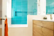 a bold small modern bathroom with a blue tile accent wall, a stained vanity, a leafy floor and a mirror