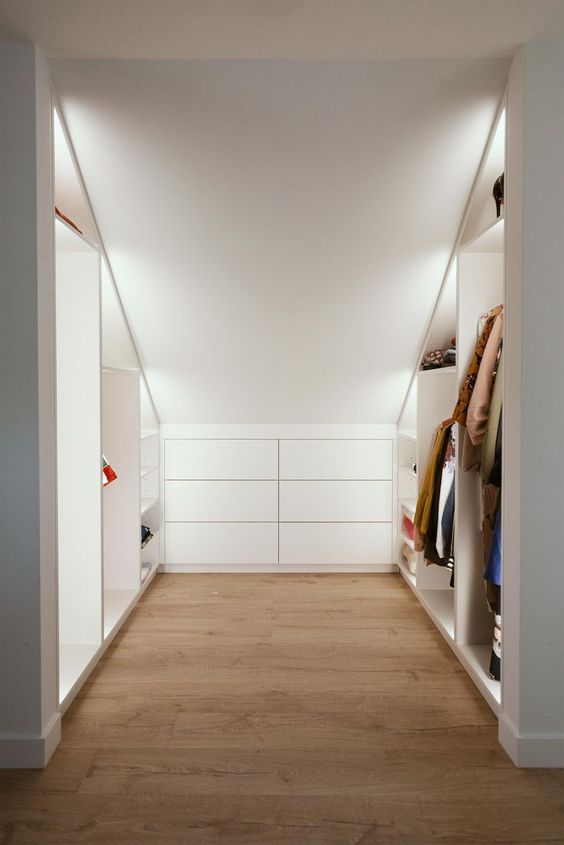 A cool modern attic ceiling closet with open shelves with built in lights and a built in dresser is a very practical solution