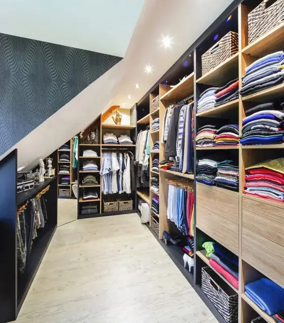 A large attic closet with open storage compartments and rails, built in storage units is a very smart and cool idea
