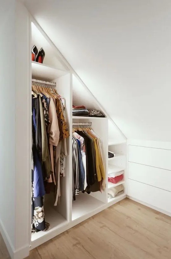 A minimalist white built in closet with built in lights and shelves is a cool solution for a small home, it's smart and cool