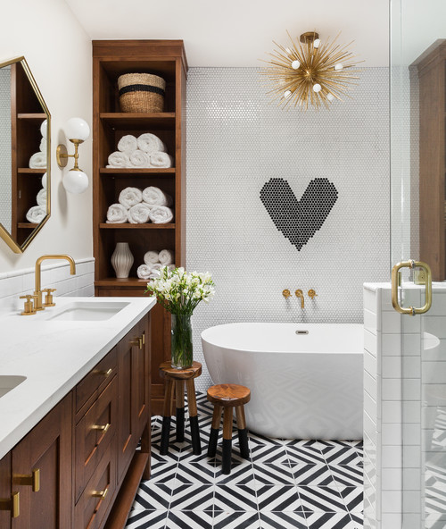 a modern bathroom with penny and printed tiles, a stained vanity and cabinets, a tub and a burst chandelier