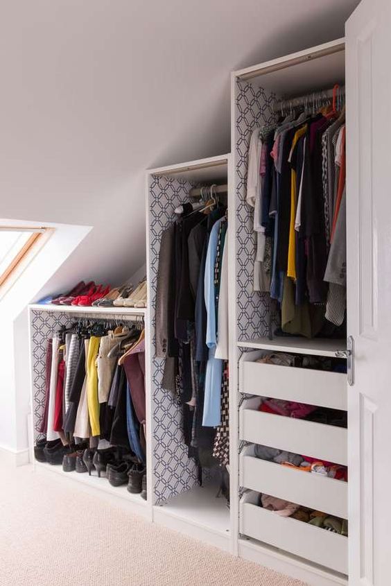 a slanted ceiling closet with open shelves and drawers and a skylight is a very cool and smart idea to rock