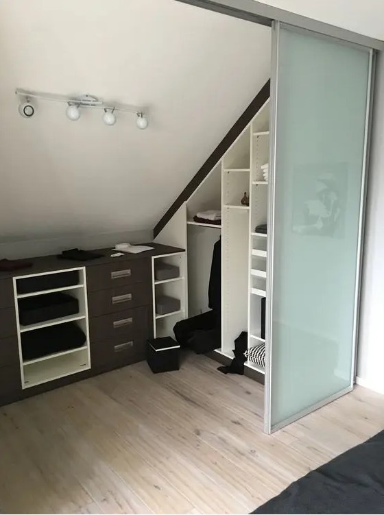 a small attic spot turned into a walk-in closet, with built-in shelves, dressers and glass sliding doors is a cool idea