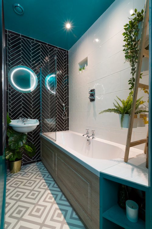a small modern bathroom with white, graphic and black tiles, a tub, a lit up mirror and some potted plants