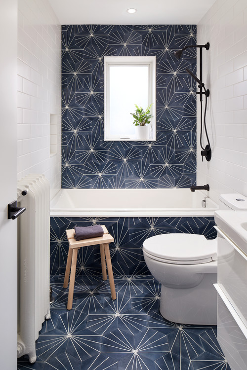 A small modern bathtoom with eye catchy hexagon tiles, white appliances and black fixtures