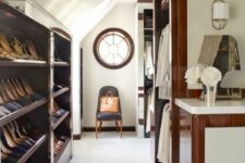 a stylish attic closet with open storag eshelves, railings for clothes, a round window is a smart and cool solution to try