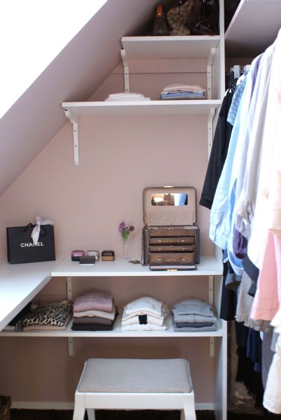 A tiny sloped walk in closet with open shelves, a stool and railing for clothes is a lovely idea for a modern space