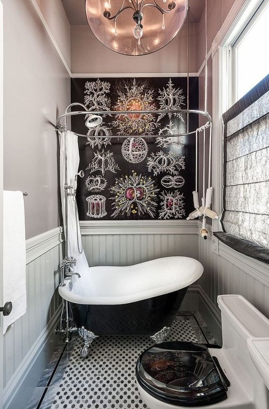 a whimsy bathroom clad with grey plaks and with a catchy floor, a small black bathtub in vintage style and a catchy accent wall