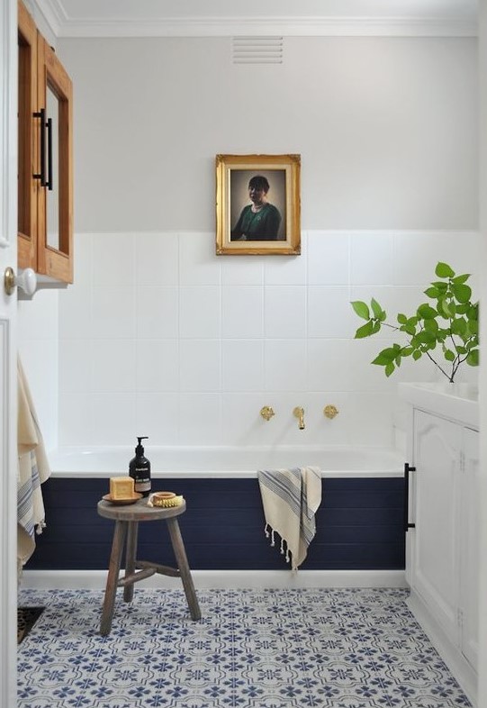 an eclectic space done in navy and white, with grey touches and natural wood plus potted greenery