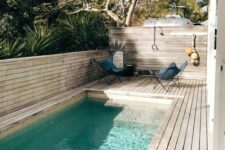 02 a chic contemporary backyard fully done with a wooden deck, butterfly chairs and a long and narrow pool