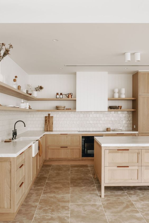 a beautiful stained kitchen with shaker cabinets, a white zellige tile backsplash, open shelves and a shiplap hood
