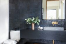 10 a modern bathroom with grey and black zellige tiles, a black floating vanity and a shelf, a mirror, a catchy pendant lamp and some decor