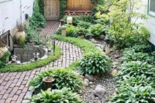 14 a lush green side yard with a lot of plants, brick paths, gravel and potted plants, too, is a very cozy and lovely space