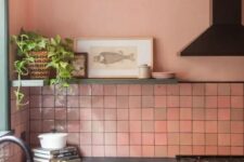 15 a gorgeous kitchen with pink zellige tiles, green cabinetry, black appliances and fixtures, a shelf with some art and a potted plant