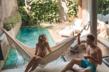 15 a small backyard pool surrounded with greenery, a with a wooden deck with loungers and a hammock is a perfect boho retreat