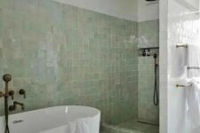 18 a neutral bathroom with bathing spaces clad with green zellige tiles and the rest of the space done with usual white ones