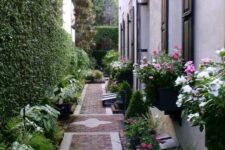 21 a beautiful and elegant floral walkway with a brick path, a living wall and lots of greenery and blooms around