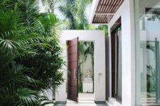 25 a contemporary side yard with pavers rising out of a shallow pool of water, with tropical greenery long them