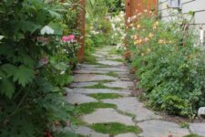30 a cozy cottage-style side yard with an irregular stone path, greenery and blooms is a cool and lovely nook