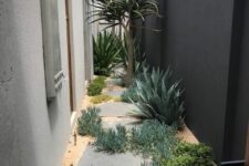 31 a desert-style side yard with irregular stepping stones, greenery and succulents and a tree is a cool and modern solution