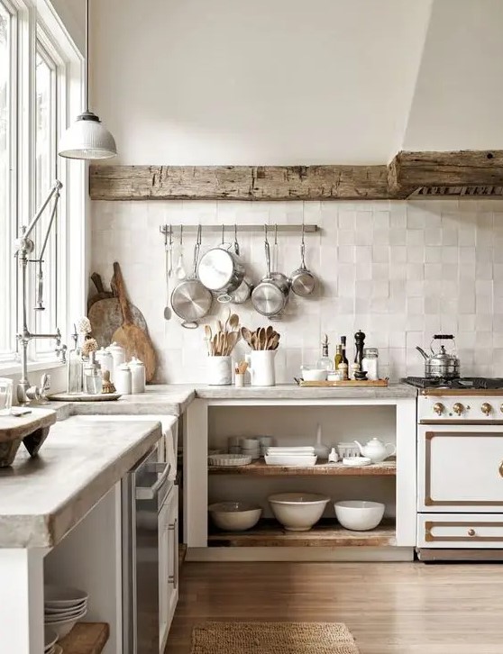 a wabi-sabi kitchen with open cabinetry, a reclaimed wooden beam covering the hood, concrete countertops and a neutral zellige tile backsplash
