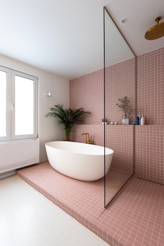 a contemporary bathroom with mauve square tiles, a shower space and an oval tub, a shelf and some decor and greenery