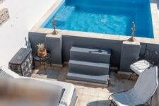 35 a lovely outdoor space with a tiled deck, a plunge pool, greenery and lanterns, some chairs, a daybed and decor