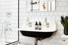 36 a contrasting modenr bathroom with white square tiles and hex tiles on the floor, a black wall-mounted sink, a mirror and some potted plants