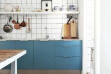37 a catchy blue Scandinavian kitchen with only lower cabinets, a white square tile backsplash, an open shelf and a stained kitchen island