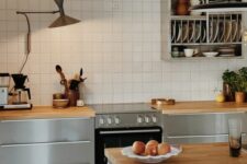 38 a catchy Nordic kitchen with sleek grey cabinets, butcherblock countertops, a white square tile backsplash and a shelf