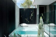 39 a minimalist outdoor space with a plunge pool in stone, a pillow, some agaves and cacti is an amazing nook